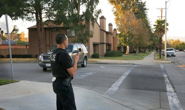 A police officer surveys a row of homes in Redlands, California, Wednesday, Dec. 2, 2015, as officials executed a search warrant following a shooting that killed multiple people at a social services center for the disabled in San Bernardino. (AP) A police officer surveys a row of homes in Redlands, California, Wednesday, Dec. 2, 2015, as officials executed a search warrant following a shooting that killed multiple people at a social services center for the disabled in San Bernardino. (AP)
