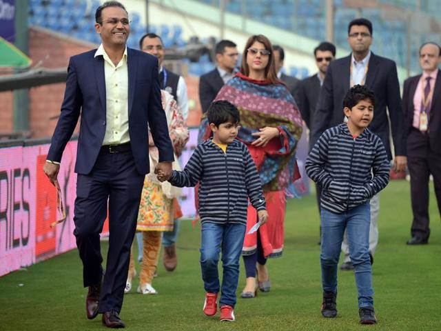 Former Indian cricketer Virender Sehwag (L) arrives with his family for a felicitation ceremony before the start of the match. Sehwag was felicitated by the Board of Control for Cricket in India (BCCI) for his accomplishments in cricket. (AFP Photo)