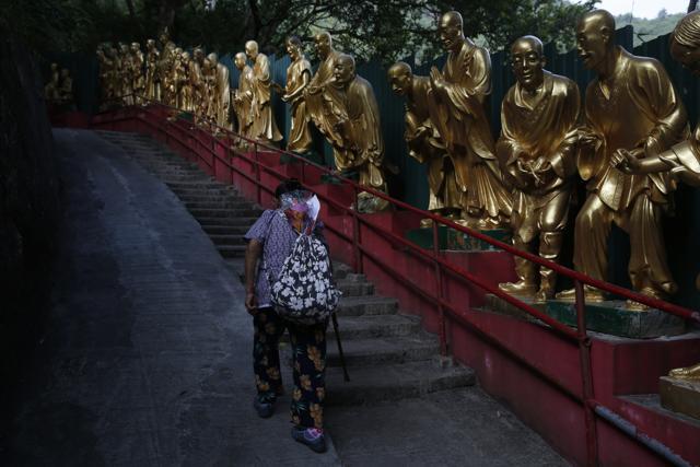 In this Dec. 1, 2015, an elderly woman walks up a staircase at Ten Thousand Buddhas Monastery, a Hong Kong temple and tourist attraction that also houses one of the more than 120 columbariums that the government has deemed illegal because they violate planning and land-use regulations. (AP) In this Dec. 1, 2015, an elderly woman walks up a staircase at Ten Thousand Buddhas Monastery, a Hong Kong temple and tourist attraction that also houses one of the more than 120 columbariums that the government has deemed illegal because they violate planning and land-use regulations. (AP)