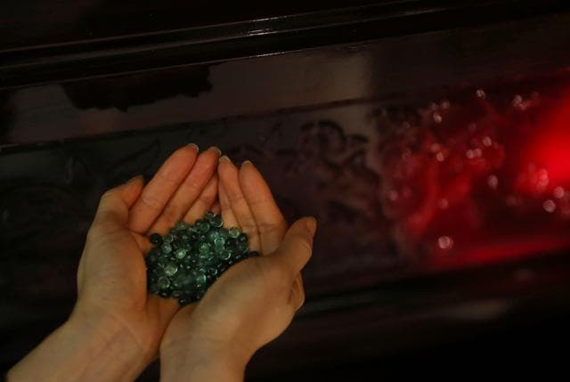 In this Dec. 2, 2015, Betsy Ma, sales director at Sage Funeral Services, displays some crystallized beads created from cremated ashes that can be used to make memorial gems. (AP) In this Dec. 2, 2015, Betsy Ma, sales director at Sage Funeral Services, displays some crystallized beads created from cremated ashes that can be used to make memorial gems. (AP)