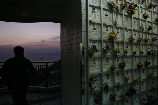 In this Nov. 22 photo, a man walks past a wall of niches for cremated remains in the background at a public columbarium in Hong Kong. (AP) In this Nov. 22 photo, a man walks past a wall of niches for cremated remains in the background at a public columbarium in Hong Kong. (AP)