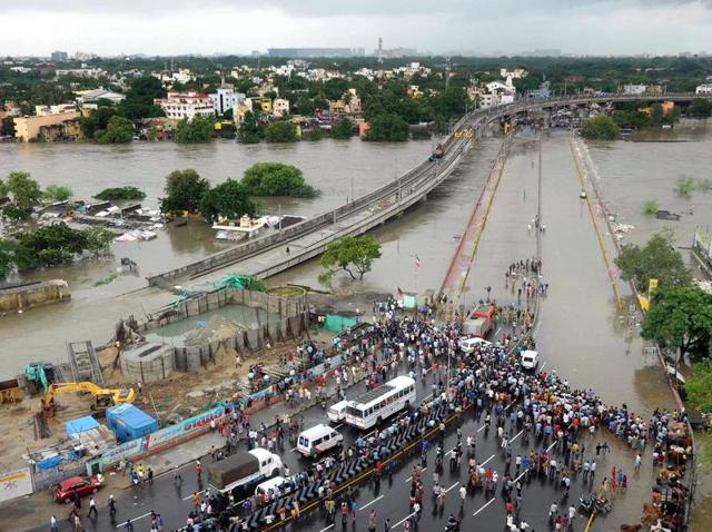 A man tries to move to a safer place from flooded Kotturpuram area after heavy rains in Chennai on Wednesday.(PTI) A man tries to move to a safer place from flooded Kotturpuram area after heavy rains in Chennai on Wednesday.(PTI)