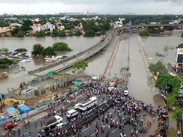 Bystanders and travellers gather as floodwaters lap at the end of a highway in Chennai. Troops have been deployed in Tamil Nadu after heavy rains worsened weeks of flooding. (AFP)