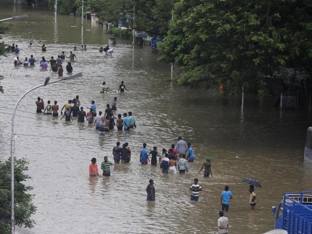 People wade through a flooded road in Chennai. (AP)