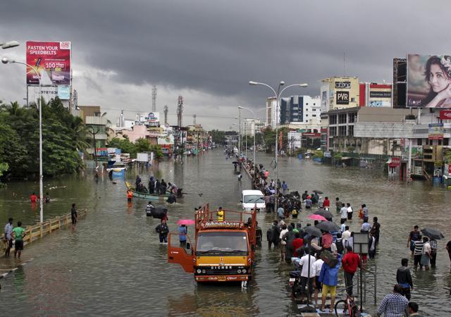 People stand on a flooded road in Chennai, December 2, 2015. (REUTERS) People stand on a flooded road in Chennai, December 2, 2015. (REUTERS)