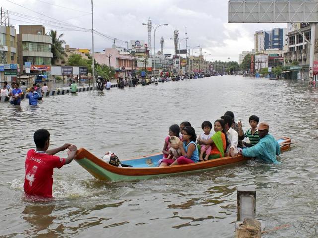 People travel on a boat as they move to safer places through a flooded road in Chennai. (REUTERS)