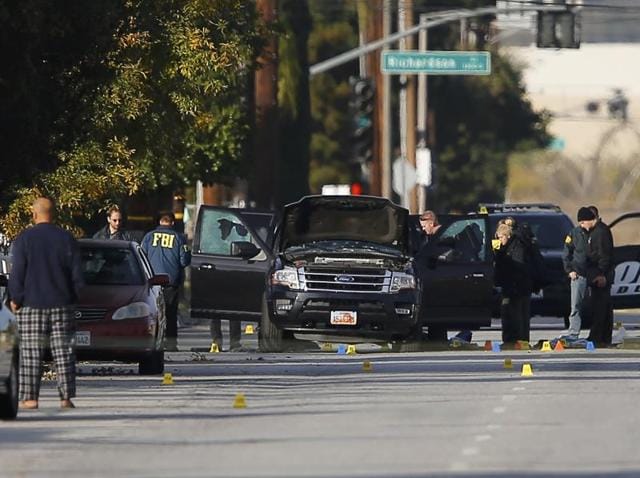 A police officer stands guard inside an area roped off with crime scene tape near a home being investigated by police.(AP)