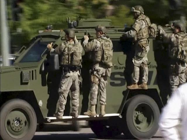 Police SWAT team units arrive on an armoured vehicle outside the Inland Regional Centre in San Bernardino. (REUTERS Photo)