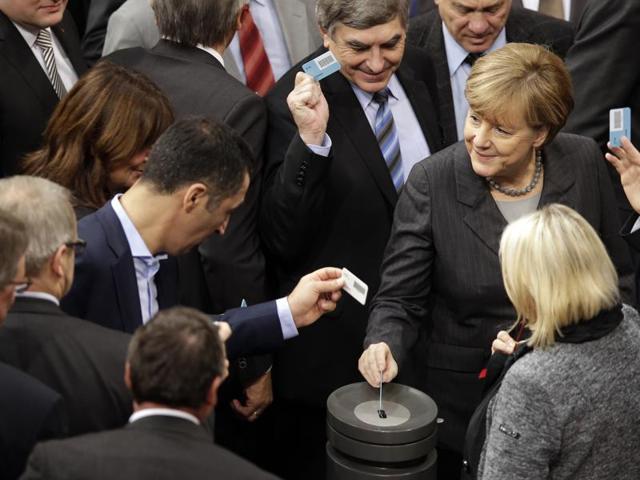 German Chancellor Angela Merkel casts her vote at the German Federal Parliament in Berlin. Parliamentarians have to vote whether Germany will join the international alliance in their fight against the Islamic State in Syria. (AP) German Chancellor Angela Merkel casts her vote at the German Federal Parliament in Berlin. Parliamentarians have to vote whether Germany will join the international alliance in their fight against the Islamic State in Syria. (AP)