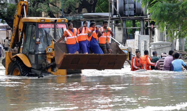 Rescue workers travel in the bucket of a bulldozer as they navigate through floodwaters in Chennai. (AFP Photo) Rescue workers travel in the bucket of a bulldozer as they navigate through floodwaters in Chennai. (AFP Photo)