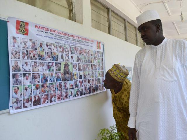 In this file photo, people look at a poster featuring wanted Boko Haram members, pasted onto the wall by the Nigeria army in Maiduguri, Nigeria.(AP Photo)