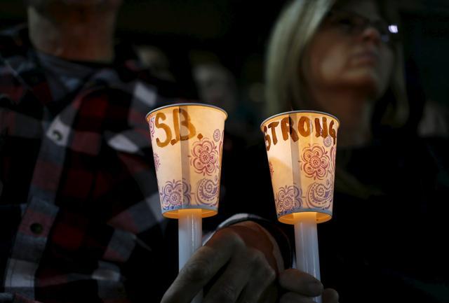 Attendees hold candles with a hand written message as they reflect on the tragedy of Wednesday's attack during a candlelight vigil in San Bernardino. (REUTERS) Attendees hold candles with a hand written message as they reflect on the tragedy of Wednesday's attack during a candlelight vigil in San Bernardino. (REUTERS)