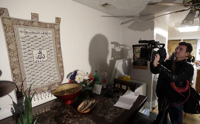 A member of the media films a wall tapestry displaying religious writing in the living room inside the home of suspects Syed Rizwan Farook and Tashfeen Malik in Redlands, California. (AP) A member of the media films a wall tapestry displaying religious writing in the living room inside the home of suspects Syed Rizwan Farook and Tashfeen Malik in Redlands, California. (AP)