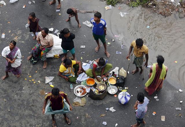 Displaced residents cook their meal on a flooded roadside in Chennai (Reuters/Anindito Mujherjee)