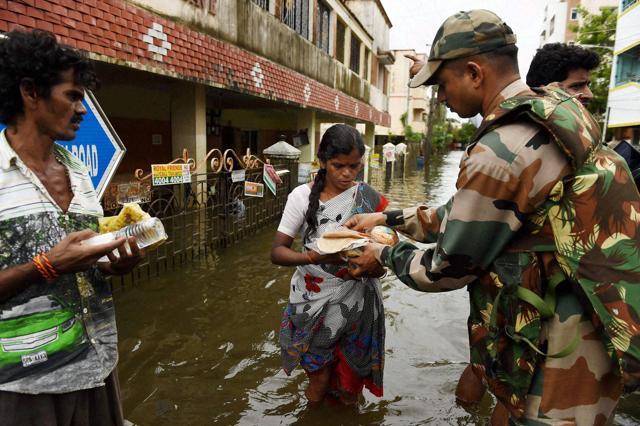 An Indian Army soldier distributes relief material to flood-affected people in Chennai. (AP) An Indian Army soldier distributes relief material to flood-affected people in Chennai. (AP)