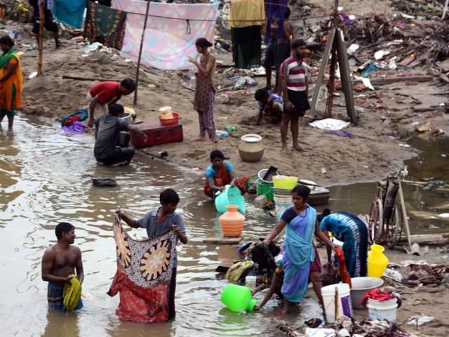Flood affected people stand in a long queue to get relief materials at Kotturpuram, one of the worst flood-hit localities in Chennai on Sunday.(PTI Photo)
