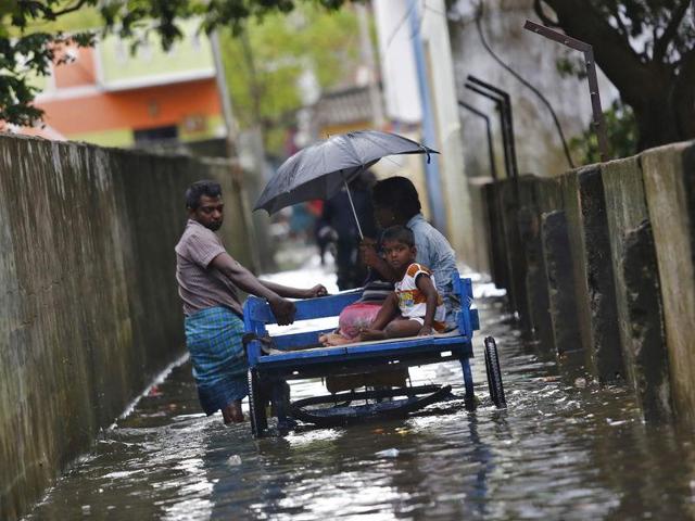 A coastguard sailor surveys an area inundated by floodwaters in Chennai.(AP Photo)