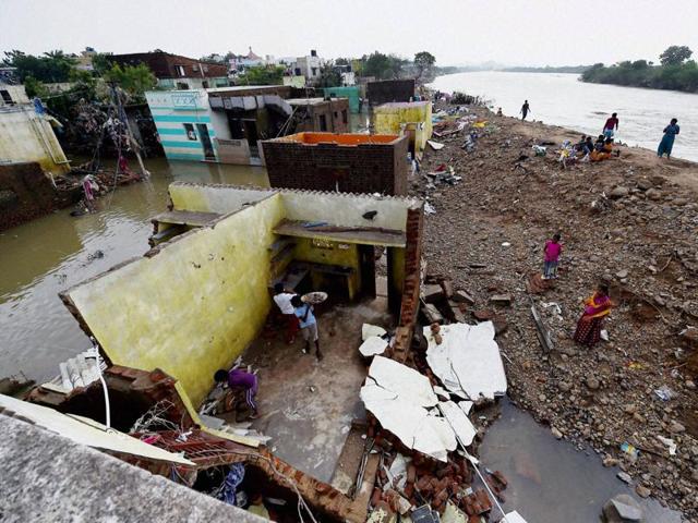 People attempt to rebuild their flood damaged houses near the banks of the Adyar River at Anakaputhur in outskirts of Chennai. (PTI Photo)