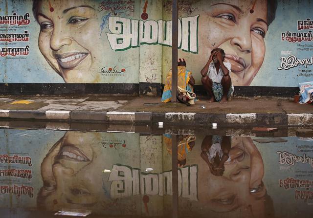 A flood-affected couple sits along a flooded roadside under a picture of Jayalalithaa, chief minister of Tamil Nadu. (REUTERS) A flood-affected couple sits along a flooded roadside under a picture of Jayalalithaa, chief minister of Tamil Nadu. (REUTERS)