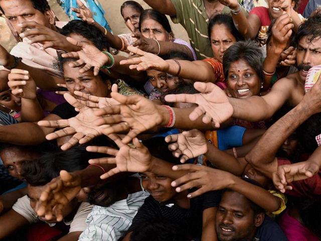 Resident of the low-income Kotturpuram area wait in line for relief materials. (PTI Photo)