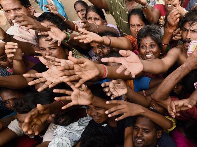 Residents seeking relief materials from volunteers at Kotturpuram, one of the worst flood-hit localities in Chennai on Monday.(PTI)