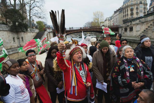 Representatives of various indigenous peoples groups participate in a prayer session about a boat on the River Seine in Paris. (AFP)