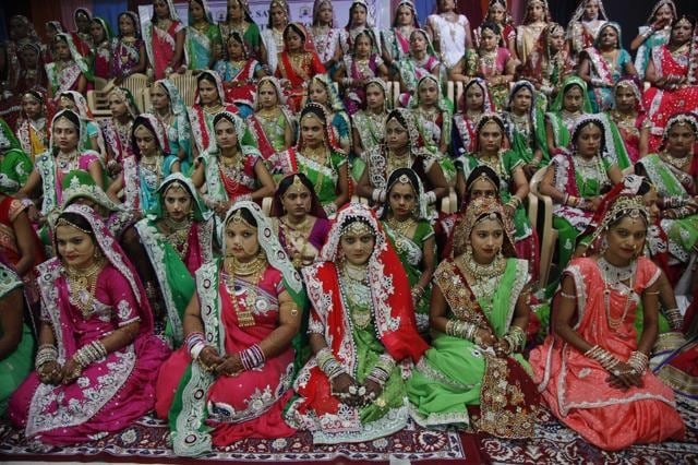 Brides sit for a group photo before a mass wedding hosted by a diamond trader in Surat. (AP) Brides sit for a group photo before a mass wedding hosted by a diamond trader in Surat. (AP)