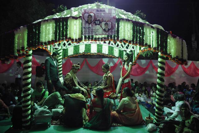 Bride Mittal Gondaliya, center right, and groom Pankaj Nasit perform rituals during a mass wedding. (AP) Bride Mittal Gondaliya, center right, and groom Pankaj Nasit perform rituals during a mass wedding. (AP)