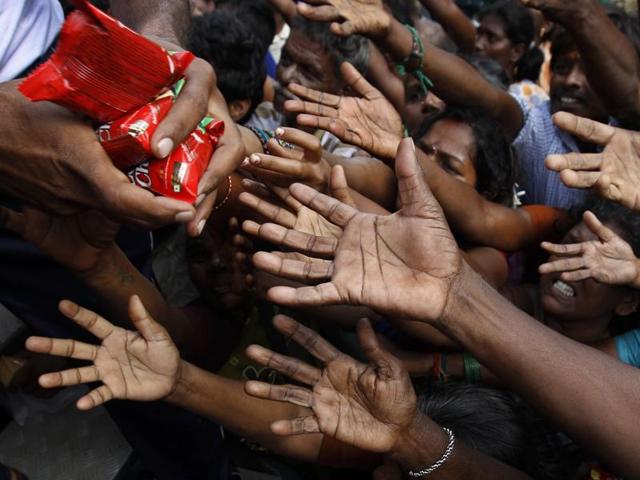 People reach out to collect relief materials being distributed in Chennai. (AP) People reach out to collect relief materials being distributed in Chennai. (AP)
