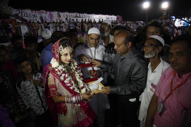 Diamond trader Mahesh Savani, center right, gives gifts to bride Nagmabegum Qadri during a mass wedding hosted by him in Surat. (AP) Diamond trader Mahesh Savani, center right, gives gifts to bride Nagmabegum Qadri during a mass wedding hosted by him in Surat. (AP)