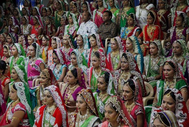Diamond trader Mahesh Savani, top center wearing white, poses for a group photo along with brides before mass wedding hosted by him in Surat. (AP) Diamond trader Mahesh Savani, top center wearing white, poses for a group photo along with brides before mass wedding hosted by him in Surat. (AP)