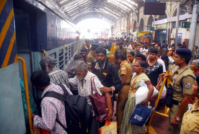 Passengers wait in a queue to board a train at the Egmore Railway Station in Chennai after Southern Railway decided to resume operations on Sunday. (PTI Photo) Passengers wait in a queue to board a train at the Egmore Railway Station in Chennai after Southern Railway decided to resume operations on Sunday. (PTI Photo)
