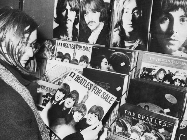 In this December 10, 1980 photo, a Beatles fan holds a vintage record album Beatles for Sale in a re cord shop in Stuttgart, Germany. (AP)