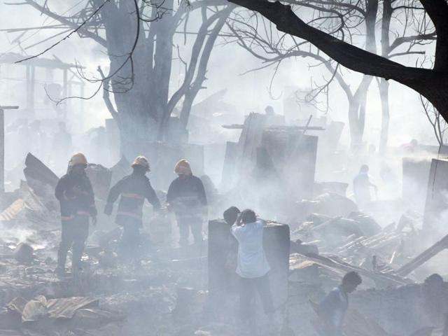 Authorities finally broke down compound walls on both sides of the access road to reach the site of the blaze. (Pratham Gokhale/ HT Photo)