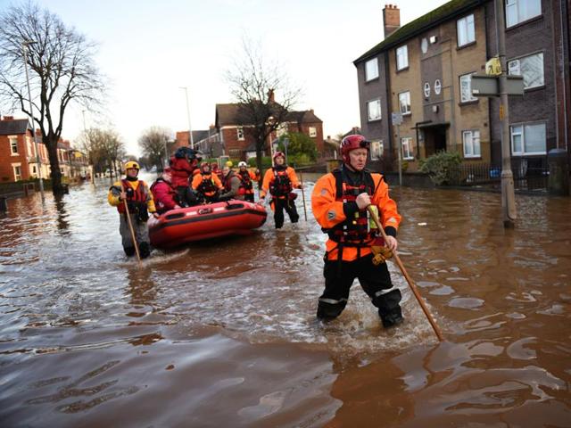 Members of the emergency services walk through flood waters as they prepare to rescue residents from their flooded properties at dusk in Carlisle. (AFP Photo) Members of the emergency services walk through flood waters as they prepare to rescue residents from their flooded properties at dusk in Carlisle. (AFP Photo)