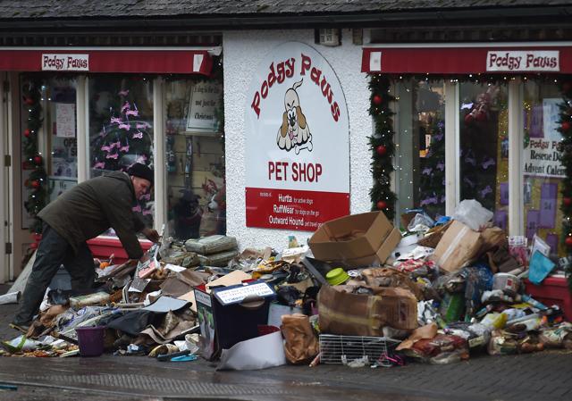 A man places flood damaged goods outside a shop in Keswick, northern England. (AFP Photo) A man places flood damaged goods outside a shop in Keswick, northern England. (AFP Photo)