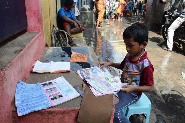 A boy puts his school books out to dry as floodwaters recede in Chennai . (AFP) A boy puts his school books out to dry as floodwaters recede in Chennai . (AFP)
