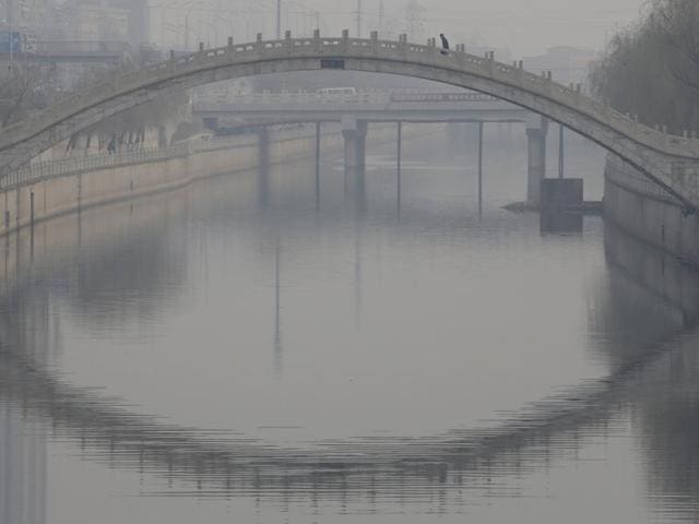 A man walks on a bridge on a hazy day in Beijing, China. (REUTERS)