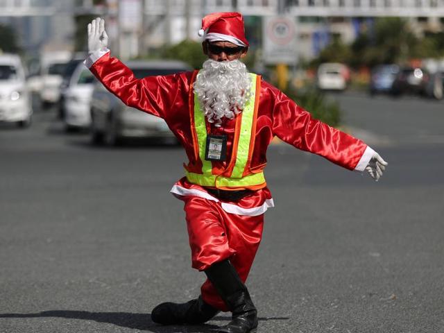 Filipino traffic enforcer Ramiro Hinojas dressed in a Santa Claus costume directs a flow of vehicles in a dancing way along a busy intersection in suburban Pasay, south of Manila, Philippines, Tuesday, December 8, 2015. Hinojas said his dance moves were influenced by Michael Jackson and hopes that people will be entertained as they wait during the Christmas gridlock. (AP) Filipino traffic enforcer Ramiro Hinojas dressed in a Santa Claus costume directs a flow of vehicles in a dancing way along a busy intersection in suburban Pasay, south of Manila, Philippines, Tuesday, December 8, 2015. Hinojas said his dance moves were influenced by Michael Jackson and hopes that people will be entertained as they wait during the Christmas gridlock. (AP)