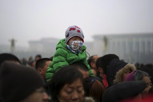 A boy wearing a mask sits on the shoulders of a man as they watch a flag-raising ceremony amid heavy smog at the Tiananmen Square. (REUTERS) A boy wearing a mask sits on the shoulders of a man as they watch a flag-raising ceremony amid heavy smog at the Tiananmen Square. (REUTERS)