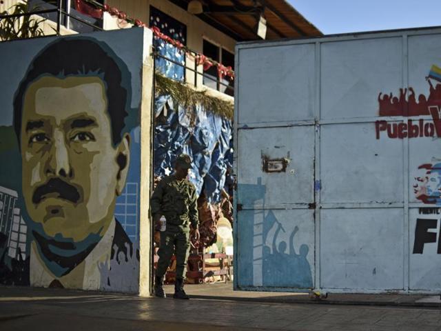 A Venezuelan soldiers walks next to a mural depicting Venezuelan President Nicolas Maduro at the entrance of a school in Caracas, on December 7, 2015. (AFP) A Venezuelan soldiers walks next to a mural depicting Venezuelan President Nicolas Maduro at the entrance of a school in Caracas, on December 7, 2015. (AFP)