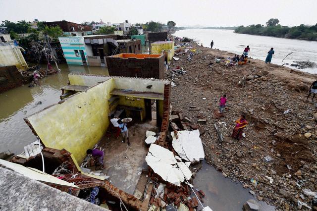 People busy in reconstruction of their flood damaged houses near the banks of the Adyar River at Anakaputhur in outskirts of Chennai. (PTI)