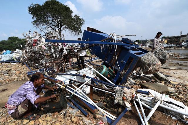 People try to salvage reusable material from their flood damaged Machine on the banks of the Adyar River at Anakaputhur outskirts of Chennai. (PTI)