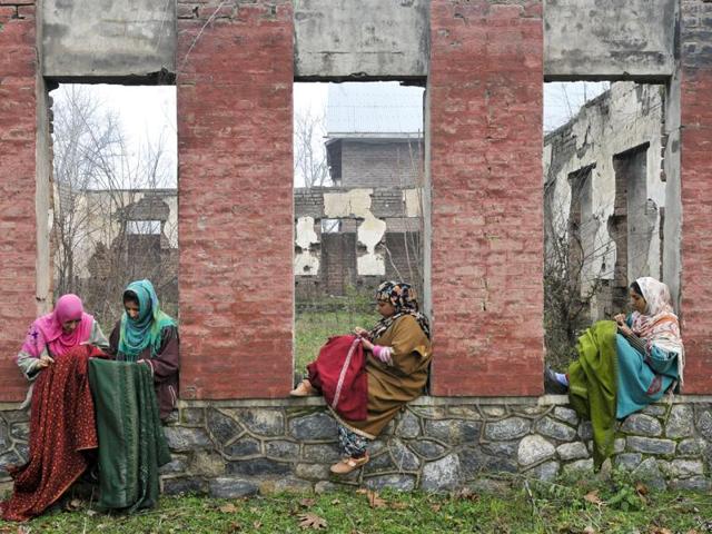 Kashmiri women sit outside and do embroidery on shawls. (Waseem Andrabi/HT Photo)
