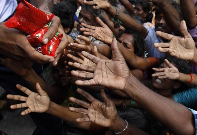 People reach out to collect relief materials being distributed in Chennai. (AP)
