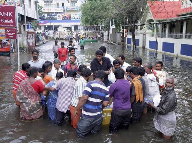 Tamil actor and director Radhakrishnan Parthiban distributes food packets to flood-affected people in Chennai.(PTI)