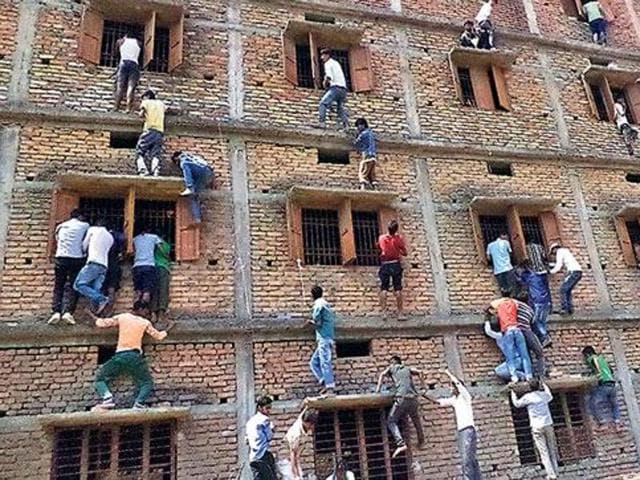Family members and friends scaling wall of a government school at Mahnar in Bihar’s Vaishali district to pass on answer chits to the students appearing in Class 10 exam in March this year. (HT file photo) Family members and friends scaling wall of a government school at Mahnar in Bihar’s Vaishali district to pass on answer chits to the students appearing in Class 10 exam in March this year. (HT file photo)