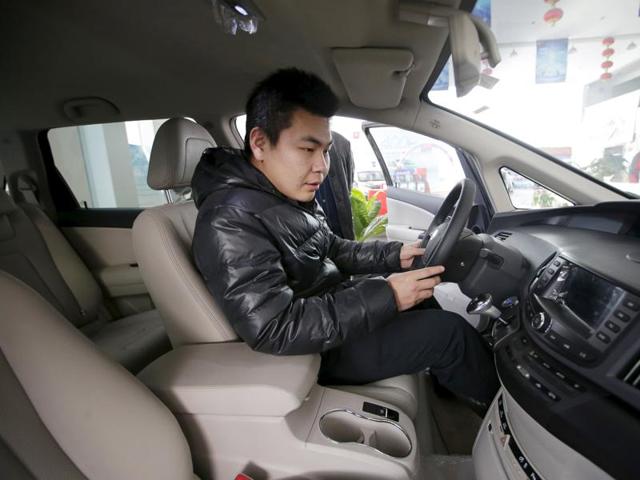 A customer checks a BYD e6 electric car at a dealership in Beijing. (Reuters photo) A customer checks a BYD e6 electric car at a dealership in Beijing. (Reuters photo)