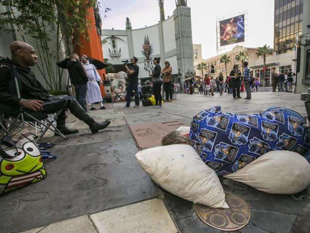 Star Wars fans Deuce Wayne, from Virginia, far left, and Larry Ross from La Crescenta, Calif., right, rest while waiting in line up outside the TCL Chinese Theater Imax for the Star Wars: The Force Awakens premiere in Los Angeles. (AP) 