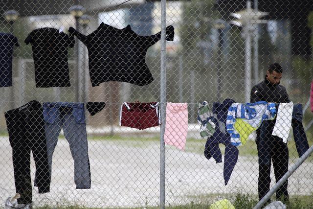 A migrant checks a pair of trousers as clothes are hung on a fence at a former Olympic indoor stadium in Faliro, southern Athens. Hundreds of people have been temporary housed in the stadium after being removed this week from Greece's northern border with Macedonia. (AP Photo) A migrant checks a pair of trousers as clothes are hung on a fence at a former Olympic indoor stadium in Faliro, southern Athens. Hundreds of people have been temporary housed in the stadium after being removed this week from Greece's northern border with Macedonia. (AP Photo)